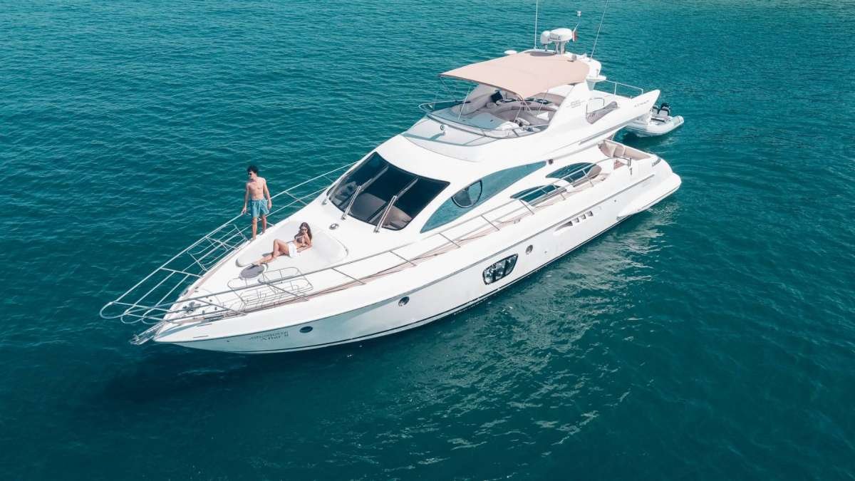 Andaman Azimut 55 flybridge motor yacht anchored in clear water off Phuket